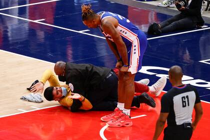 Dwight Howard, de Philadelphia 76er,  mira al fanático que corrió hacia la cancha y fue abordado por la seguridad en el tercer cuarto del juego cuatro de la serie de primera ronda de la Conferencia Este ante Washington Wizards, en Capital One Arena