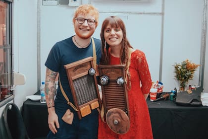 Ed Sheeran y la cantante argentina Silvina Moreno posan con una washboard. En su último paso por Argentina, el músico británico recibió una edición argentina del instrumento que se hizo popular en las orquestas de swing