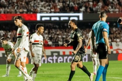 Edwin Cardona, de Atlético Nacional, le festeja el gol de su equipo a Ferraresi, de San Pablo; el árbitro Ramírez, atento al hecho, le mostrará la segunda amarilla al colombiano, exnúmero 10 de Boca