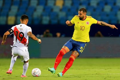 Edwin Cardona maniobra ante Yoshimar Yotún, uno de los titulares indiscutidos en el Perú de Ricardo Gareca