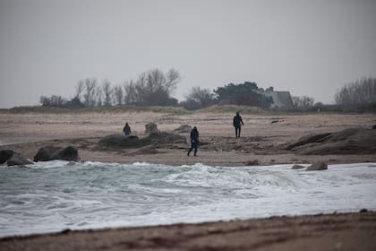 Efectivos buscan bolsas de drogas en Neville sur Mer, noroeste de Francia, el 2 de marzo. Más de dos toneladas de cocaína empacadas en bolsas fueron arrastradas el fin de semana pasado y el 1 de marzo de 2023, en la costa del Canal, con un valor minorista estimado de 150 millones de euros. (Lou BENOIST / AFP)