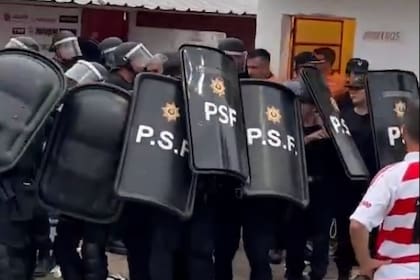Efectivos de la policía santafesina, con escudos, resguardan la salida del árbitr Andrés Merlos y sus colaboradores, tras la final de la Liga Casildense de fútbol entre Unión Deportiva Los Molinos y Belgrano de Arequito