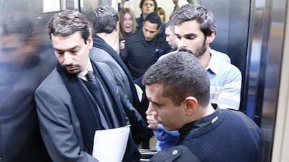 El abogado Sergio Curzi y su entonces defendido Santiago Silvoso aguardan el cierre de la puerta del ascensor ante los gritos de Adriana Aruj