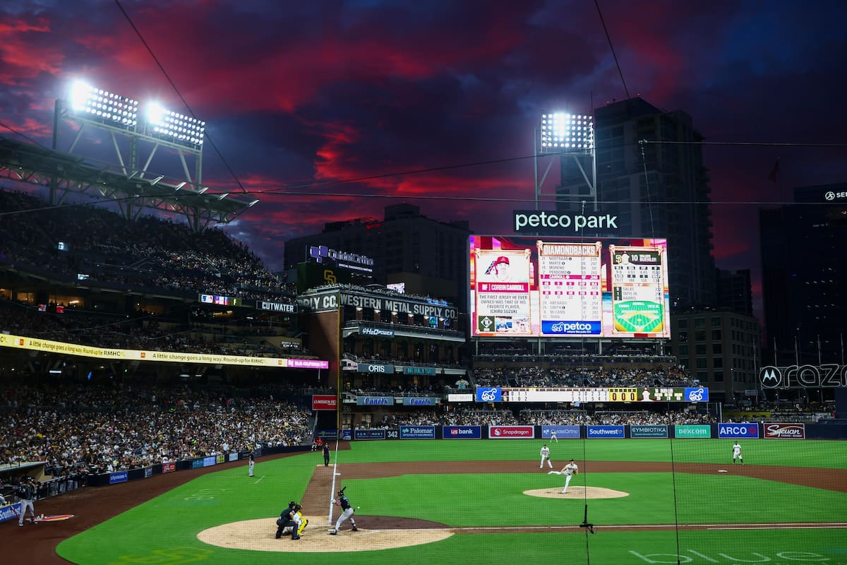 El abridor de los Padres de San Diego, Walker Buehler (centro), realiza un lanzamiento hacia Corbin