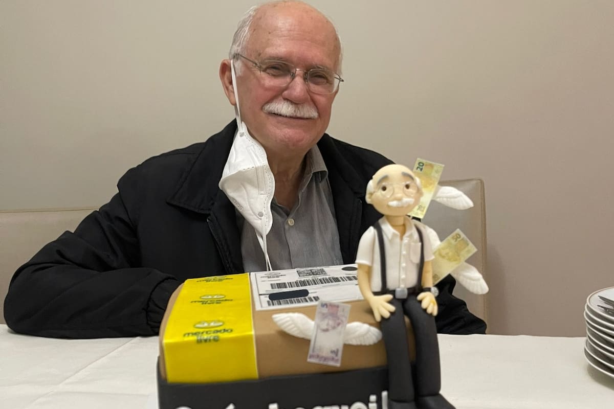 El abuelo posa sonriente con la torta de la compañía que tanto admira