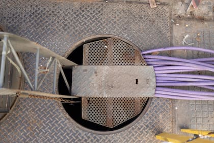 El acceso a la infraestructura subterránea donde se encuentra la cámara eléctrica dañada que Edesur trabaja para reconstruir