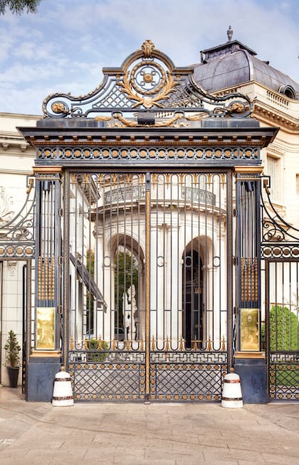 El acceso sobre la calle Pereyra lucena resguarda un pequeño jardín que emula el Petit Trianon de Versalles. El gran portón de hierro forjado y bronce da acceso al Patio de Honor.