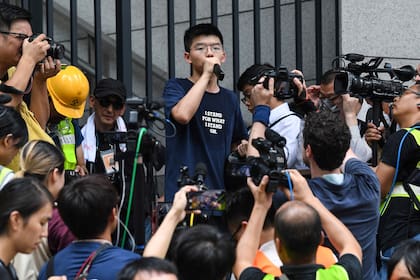 El activista prodemocracia Joshua Wong habla con manifestantes frente a la sede de la policía en Hong Kong, en junio de 2019