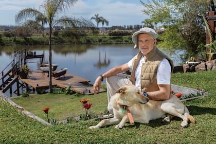 El actor posa en el jardín de su casa junto con Tomillo. Detrás, un canal que sale al río Luján