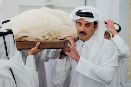 El actual emir, Tamim bin Hamad Al Thani, carga el cuerpo de su padre durante la procesión encabezando el cortejo