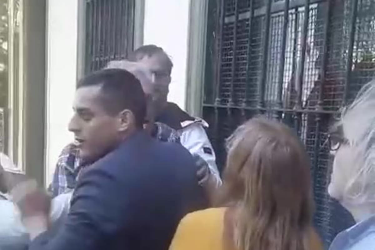 El agresor está tapado por el hombre de saco azul, que intenta evitar el ataque (captura de pantalla)