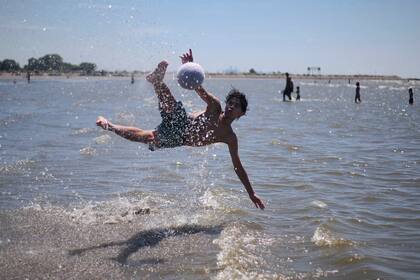 El agua en la costa de Quilmes no era profunda, pero los chicos disfrutaron jugado a la pelota