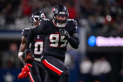 El ala defensiva de los Texans de Houston, Derek Barnett, corre con el balón mientras anota en una recuperación de balón suelto durante la segunda mitad de un partido contra los Cowboys de Dallas, el lunes 18 de noviembre de 2024, en Arlington, Texas. (AP Foto/Jerome Miron)
