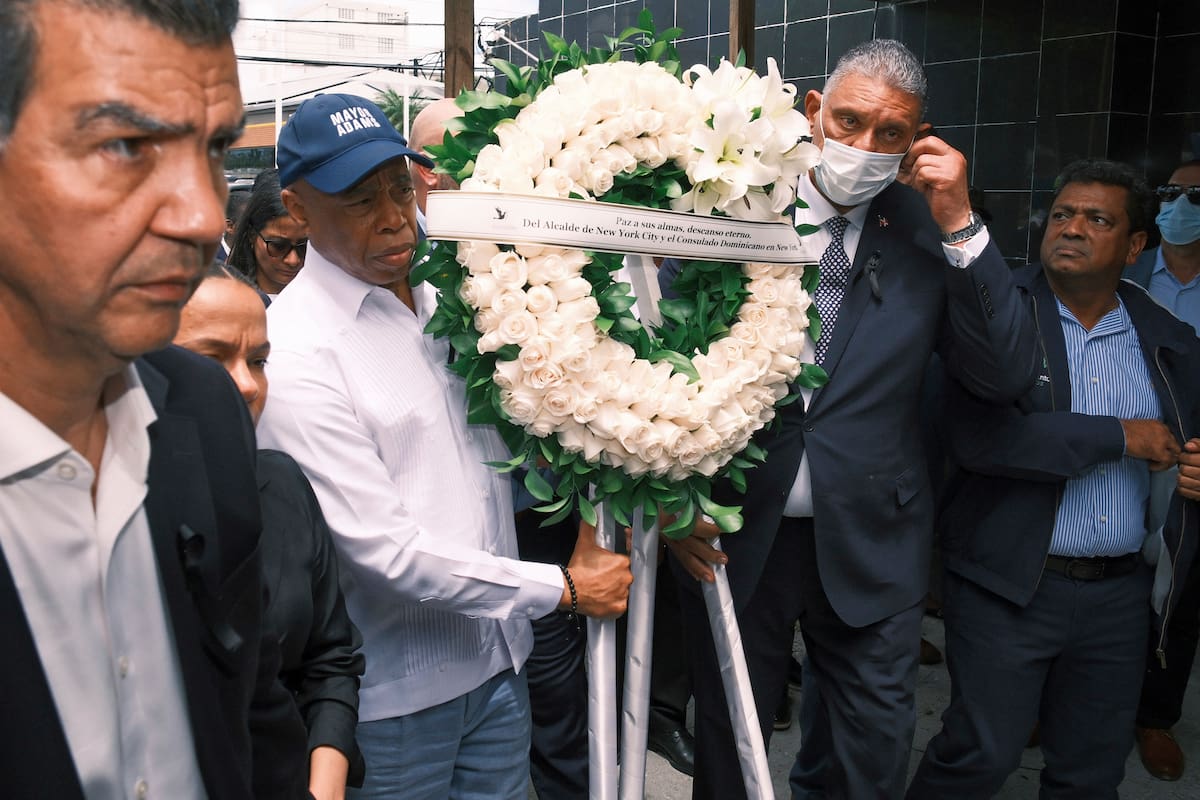 El alcalde de la ciudad de Nueva York, Eric Adams, segundo a la izquierda, lleva una corona de flores en memoria de las más de 200 personas que murieron la semana pasada por el colapso del techo del centro nocturno Jet Set, en Santo Domingo, República Dominicana, el lunes 14 de abril de 2025. (AP Foto/Ricardo Hernández)