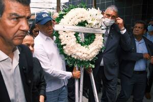 El alcalde de la ciudad de Nueva York, Eric Adams, segundo a la izquierda, lleva una corona de flores en memoria de las más de 200 personas que murieron la semana pasada por el colapso del techo del centro nocturno Jet Set, en Santo Domingo, República Dominicana, el lunes 14 de abril de 2025. (AP Foto/Ricardo Hernández)
