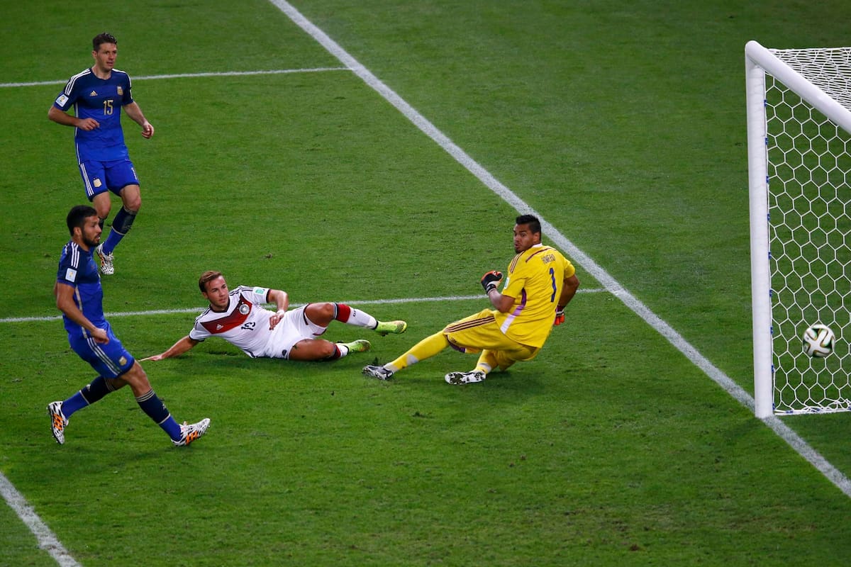El alemán Mario Goetze marca un gol ante la vista del argentino Martin Demichelis, Ezequiel Garay y el arquero Sergio Romero durante el tiempo extra en su final de la Copa Mundial 2014 en el estadio Maracaná de Río de Janeiro el 13 de julio de 2014.
