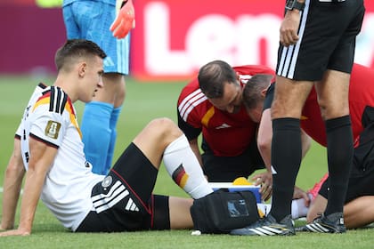 El alemán Nico Schlotterbeck es atendido por los médicos durante el partido entre Alemania y Costa de Marfil; la lesión en su tobillo izquierdo lo dejó afuera del Mundial