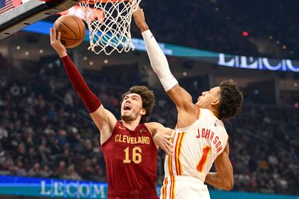 El alero de los Cavaliers de Cleveland Cedi Osman lanza el balón superando al alero de los Hawks de Atlanta Jalen Johnson en el encuentro del lunes 21 de noviembre del 2022. (AP Foto/Nick Cammett)