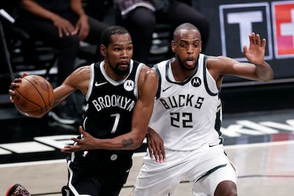 El alero de los Nets de Brooklyn, Kevin Durant, pasa frente al alero de los Bucks de Milwaukee, Khris Middleton, durante la segunda parte del juego de la NBA, el sábado 5 de junio de 2021, en Nueva York. (AP Foto/Adam Hunger)