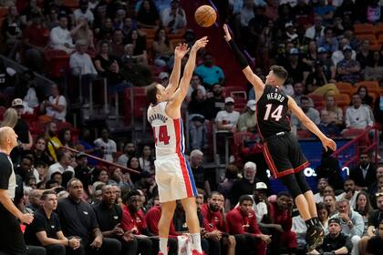 El alero de los Pistons de Detroit Bojan Bogdanovic lanza un triple mientras lo defiende Tyler Herro del Heat de Miami en el encuentro del martes 6 de diciembre del 2022. (AP Foto/Lynne Sladky)