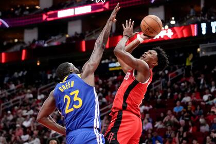 El alero de los Rockets de Houston, Amen Thompson, a la derecha, dispara mientras el alero de los Warriors de Golden State, Draymond Green, defiende durante la primera mitad el sábado 2 de noviembre de 2024, en Houston. (AP Foto/Eric Christian Smith)