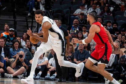 El alero de los Spurs de San Antonio Victor Wembanyama avanza con el balón frente al base de los Rockets de Houston Dillon Brooks en el encuentro del sábado 26 de octubre del 2024. (AP Foto/Michael Thomas)