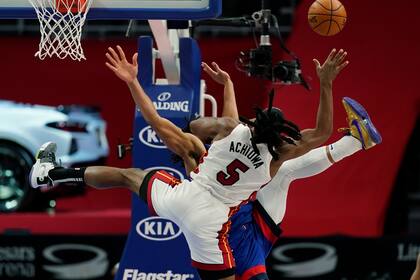 El alero del Heat de Miami Precious Achiuwa comete una falta ofensiva sobre el pívot de los Pistons de Detroit Jahlil Okafor en la segunda mitad del juego del domingo 16 de mayo de 2021, en Detroit. (AP Foto/Carlos Osorio)