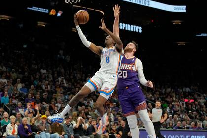 El alero del Thunder de Oklahoma City, Jalen Williams, supera al pívot de los Suns de Phoenix, Jusuf Nurkic (20), durante la primera mitad del partido de baloncesto de la NBA, el domingo 3 de marzo de 2024, en Phoenix. Los Suns de Phoenix serán los anfitriones del Juego de Estrellas de la NBA de 2027, anunció la liga el jueves. (AP Foto/Rick Scuteri)