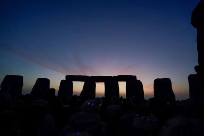 El amanecer comienza tras las piedras de Stonehenge durante las celebraciones del solsticio de verano en Wiltshire, Inglaterra, el martes 21 de junio último. Tras dos años cerrado debido a la pandemia, Stonehenge reabrió el lunes. Desde que somos humanos estar es estar en el mundo
