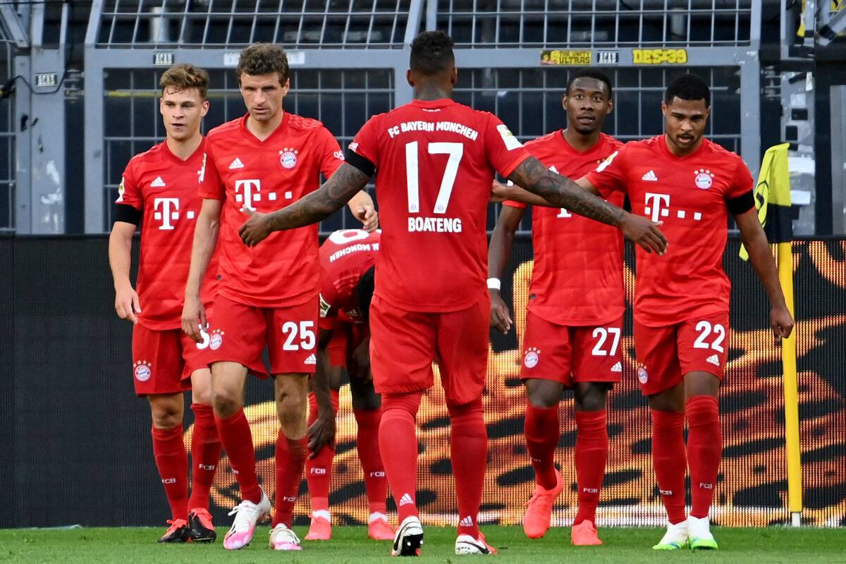 El anotador de Munich Joshua Kimmich, a la izquierda, y sus compañeros de equipo celebran el gol de apertura durante el partido de fútbol de la Bundesliga alemana entre el Borussia Dortmund y el FC Bayern Munich en Dortmund, Alemania, el martes 26 de mayo de 2020.