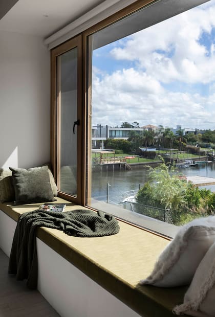 El antepecho de las ventanas se aprovechó en cada espacio de la planta alta: en la suite principal, para el futón de lectura o descanso, favorecido por las vistas al lago. Estudio MMO Arquitectas.