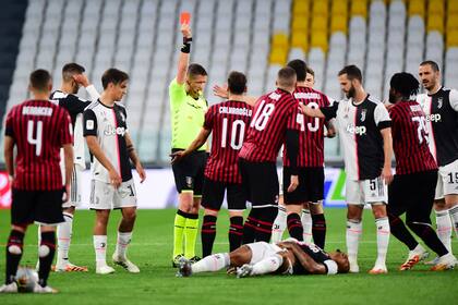 El árbitro Daniele Orsato le muestra la tarjeta roja a Ante Rebic, de Milan; el brasileño Danilo, de Juventus, recibió una patada voladora del croata y está en el piso.
