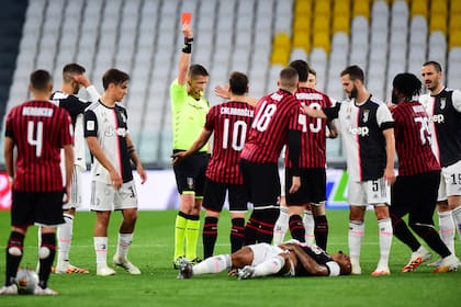 El árbitro Daniele Orsato le muestra la tarjeta roja a Ante Rebic, de Milan; el brasileño Danilo, de Juventus, recibió una patada voladora del croata y está en el piso.