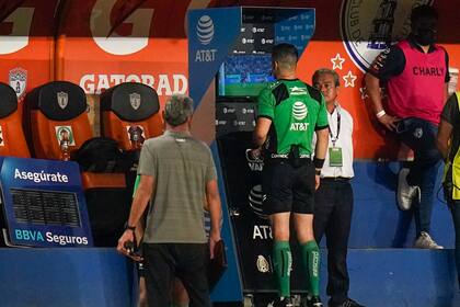 El árbitro Fernando Hernández revisa la pantalla del VAR durante el partido entre Pachuca y Atlas por el título de la liga mexicana, el 29 de mayo de 2022. (AP Foto/Eduardo Verdugo)