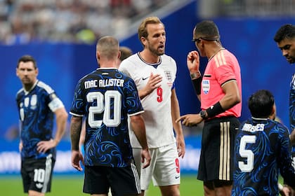 El árbitro Ismail Elfath habla con Harry Kane con Lionel Messi en el fondo y Alexis Mac Allister espaladas