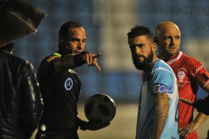El árbitro Julio Barraza se reúne con los capitanes de Victoriano Arenas y Huracán para decidir la suspensión del partido, que continuará hoy, a las 15.30.