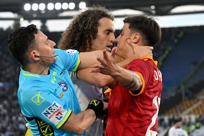 El árbitro Marco Guida intenta separar a Paulo Dybala y el francés Matteo Guendouzi en el segundo tiempo del partido entre Roma y Lazio por la Serie A