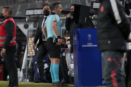 El árbitro Patricio Loustau de Argentina revisa el VAR durante un partido de la Copa Sudamericana en Santiago, Chile, el martes 28 de junio de 2022. (AP Foto/Luis Hidalgo)