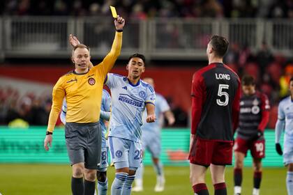 El árbitro Scott Bowman le muestra la tarjeta amarilla al defensa de Toronto Kevin Long mientras observa el delantero del Atlanta United Tyler Wolff el sábado 23 de marzo del 2024.(Arlyn McAdorey/The Canadian Press via AP)
