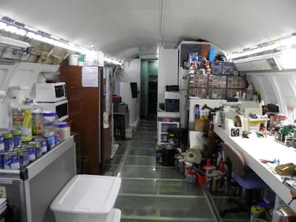El área de cocina incluye un microondas, un horno tostador, una lavadora portátil y un carrito de avión como despensa