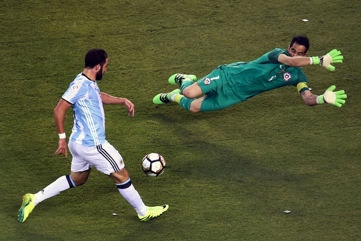 El argentino Gonzalo Higuaín se prepara para disparar sobre el portero chileno Claudio Bravo durante la final de la Copa América Centenario