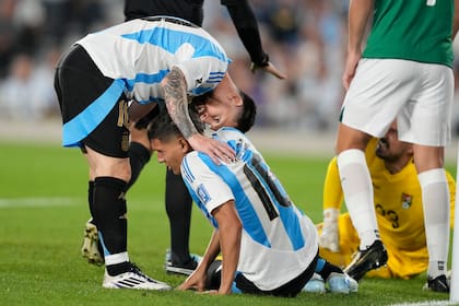 El argentino Lionel Messi revisa a su compañero de equipo Nahuel Molina, quien se encuentra en el campo con una lesión durante un partido de fútbol de clasificación para la Copa del Mundo 2026 contra Bolivia en el estadio Monumental en Buenos Aires, Argentina, el martes 15 de octubre de 2024. (AP Foto/Natacha Pisarenko)