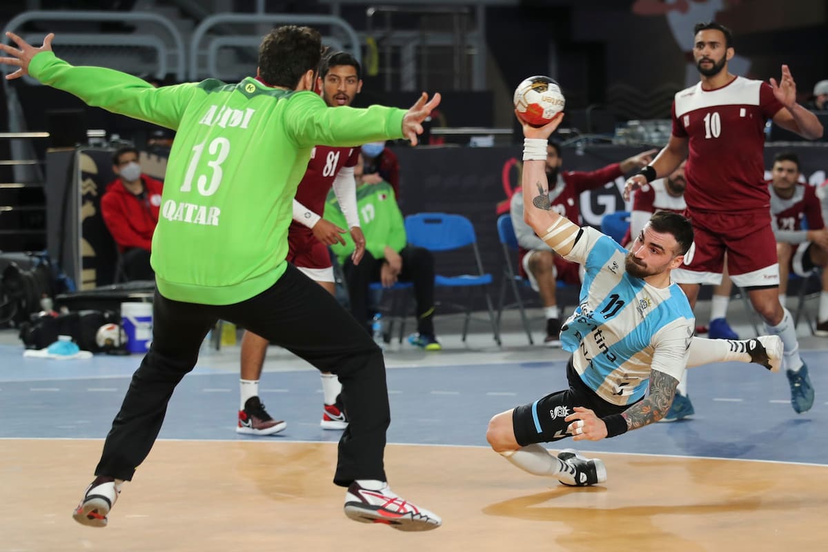 El argentino Lucas Dario Moscariello dispara junto al qatarí Mohamed Abidi durante el Campeonato Mundial de Balonmano en El Cairo, Egipto, el lunes 25 de enero de 2021