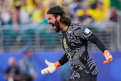 El arquero brasileño Alisson grita durante el partido ante Marruecos; jugó con la camiseta oscura y este miércoles lo hará con la verde ante Escocia