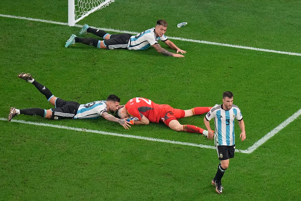 El arquero Emiliano Martínez es abrazado por Nicolás Otamendi tras una milagrosa atajada en el último suspiro frente a Australia