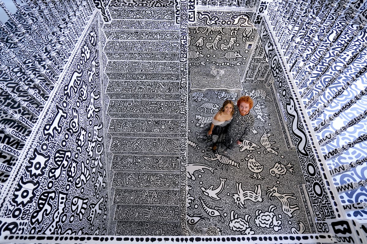 El artista británico Sam Cox, también conocido como Mr Doodle, con su esposa Alena, en la Doodle House, una mansión de 12 habitaciones que fue cubierta, por dentro y por fuera, con los característicos garabatos monocromáticos dibujados a mano por él.