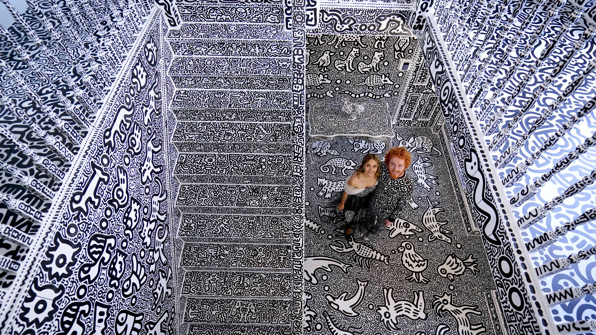 El artista británico Sam Cox, también conocido como Mr Doodle, con su esposa Alena, en la Doodle House, una mansión de 12 habitaciones que fue cubierta, por dentro y por fuera, con los característicos garabatos monocromáticos dibujados a mano por él.