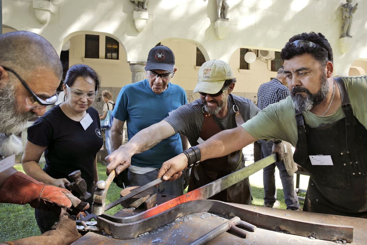 El artista chileno José Flores (der.) supervisa los trabajos de la escultura que será el símbolo del encuentro