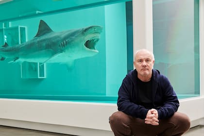 El artista Damien Hirst con su archifamoso tiburón petrificado en una pecera con formol