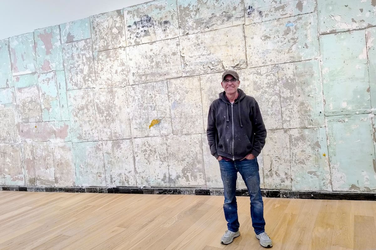 El artista Eduardo Cardozo delante de la pared desnuda, una de las obras que sorprendió en la bienal de Venecia